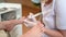 Podiatrist using grinding equipment and making procedure polish for feet pedicure. Podology beautician in white gloves cleaning