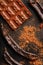 The pods of the carob chocolate bar on a black background. Sweets, chocolate and confectionery made of carob fruit