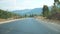 Point of view of car driving at road in scenic mountain environment. Auto riding through highway at summer day