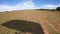 Point of view of a parachutist landing with his shadow.