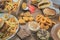 Point of view of a person eating a handmade burger, with several portions of fried snacks on the table