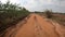 Point of view running on a dirt road. Off-road truck car wheels move on the dirty road with dust, wet and dry mud.