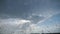 Point of view through the windshield of car with raindrops to the cloudy sky. Close up of water droplets on windowpane