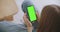 Point of View of Woman at Modern Room Sitting on a Chair Using Phone With Green Mock-up Screen Chroma Key Surfing