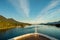 Pointed bow of cruise ship , southbound on ocean channel, Alaska Inside Passage, in warm afternoon sun.