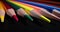 Pointed multicolored pencil tips on dark background