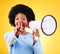 Pointing, happy woman and loudspeaker or megaphone in studio for voice or announcement. African person portrait with
