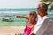 Pointing mature couple by ocean