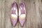 Pointy patent pumps in old pink color on wooden floor