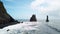 Pointy rocks sticking out of the ocean at Reynisfjara Beach near Vik in Iceland