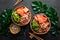 Poke bowl with raw salmon fish, chuka salad and rice in coconut bowls on black background
