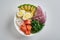 poke bowl with salmon, avocado, rice, Chuka Salad, sweet onions, quail eggs sprinkled with white and black sesame isolated on