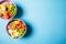 Poke bowl with salmon, rice, avocado, edamame beans, cucumber and radish in gray bowls, top view. Hawaiian ahi poke bowl, blue