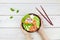 Poke bowl with salmon, rice, radish, carrot, cucumber. Hawaiian ahi in a woman\'s hands. A diet meal with fish