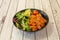 Poke bowl of spicy salmon marinated with ripe avocado, cherry tomatoes and lettuce shoots and lamb\\\'s lettuce
