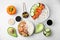 Poke bowls and ingredients on white table, flat lay