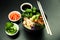 Poke salad with shrimp in a bowl. Ingredients Shrimp, blanched spinach, cherry tomatoes, rice, cucumber, soy-ginger