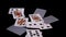 Poker cards fly and fall on a black surface