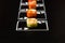 Poker cards with Japanese sushi roll pieces on dark chalkboard. Asian rolls with crunchy shrimp, cucumber, salmon and flying fish