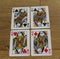 Poker cards on a wooden backround, set of queens of clubs, diamonds, spades, and hearts