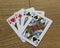 Poker cards on a wooden backround, set of queens of clubs, diamonds, spades, and hearts