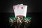 Poker game with one pairs combination. Chips and cards on dark table. Successful and win