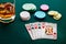 Poker hand of four aces, chips and a glass of whiskey