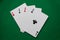 Poker hand four aces on green felt table