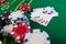 Poker play cards and chips on green table. Texas holdem