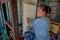 POKHARA, NEPAL - OCTOBER 06 2017: Close up of unidentified smiling woman working on loom manufacturing wool shawl