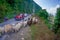 POKHARA, NEPAL, SEPTEMBER 04, 2017: Shepherds take care of flocks of goats, going along the street with some cars parked