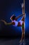 Pole dance. Flexible girl with uv bodyart posing