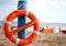 Pole with lifejacket at sea on the beach by the sea