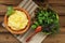 Polenta with basil shoot in wooden bowl with green salad and woo