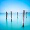 Poles and soft water on Venice lagoon. Long exposure.