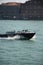 Police boat in Italy rushes along the river and in the background of ancient buildings