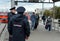 Police control public order on the railway platform near suburban electric trains.