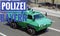 Police green armored car, with the inscription Police Bavaria police task law in full ride with motion blur