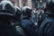Police group wearing black armor and helmets standing against protests. AI generative image