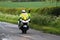 Police motor cyclist waving.