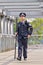 Police officer with a baton on pedestrian bridge, Beijing, China