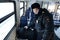 A police officer wakes up a sleeping passenger in a suburban train.