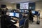 Police officers at surveillance control center room wide