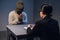 At the police station, a girl investigator interrogates a black guy who is sitting in front of her in handcuffs