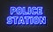 Police station neon sign on brick wall background.