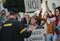 Police stopping group of people activists with raised fists protesting on streets, BLM demonstration concept.