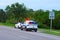 Police truck vehicle pulling over a sports car by speed limit sign