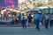 A police woman manages trafiic in a big city. Huge market in the background, crowd of people cross the street of Antananarivo