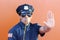 Policeman blowing whistle and showing stop hand gesture