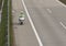 Policeman drives motorbike on highway in sunny day